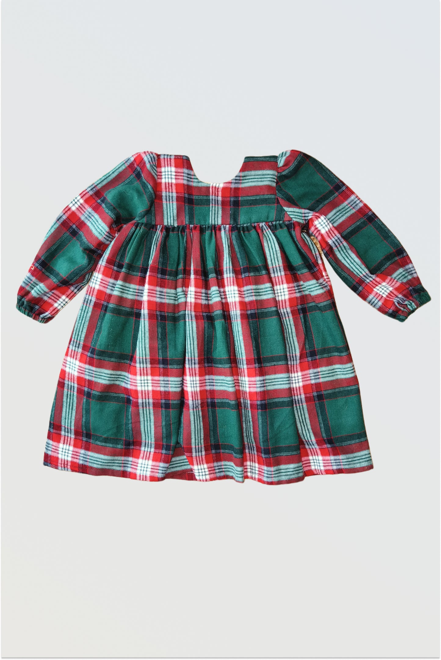 Back view of red green checkered winter dress showing single hook closure and gathered pleats