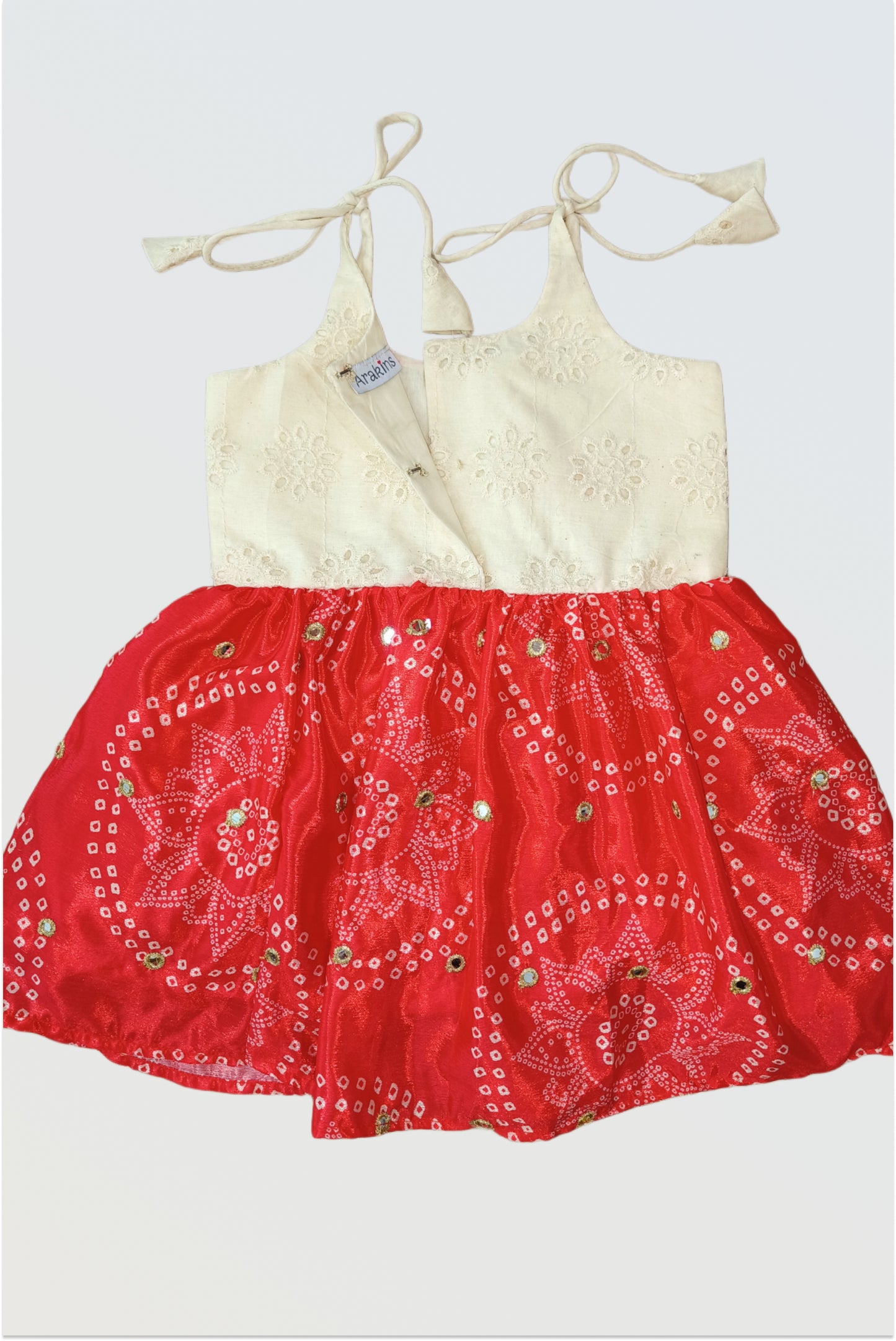 Back view of red Bandhani tie-up frock showing adjustable shoulder straps and traditional print