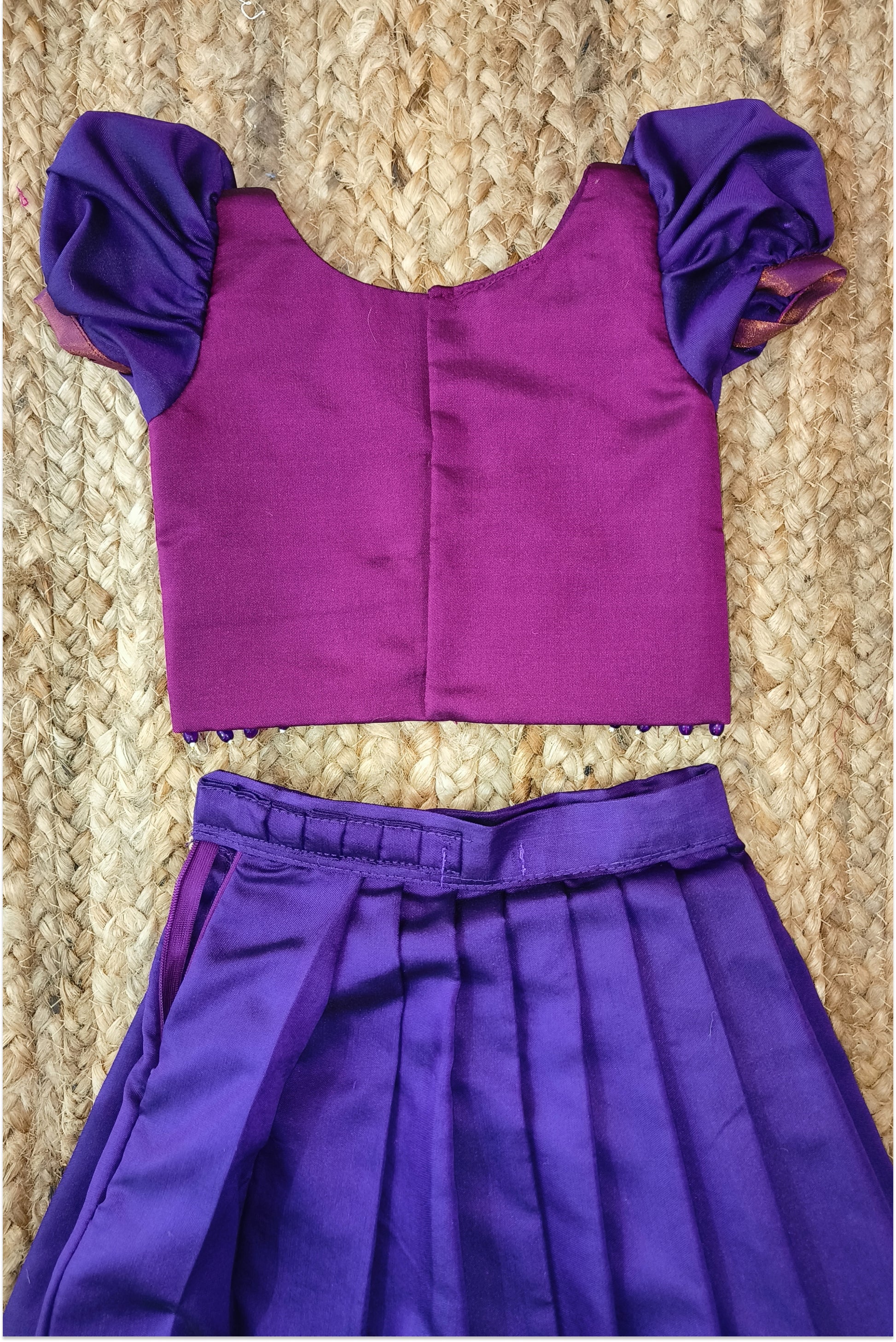 Magenta choli with golden embroidery and purple puffed sleeves - close-up detail
