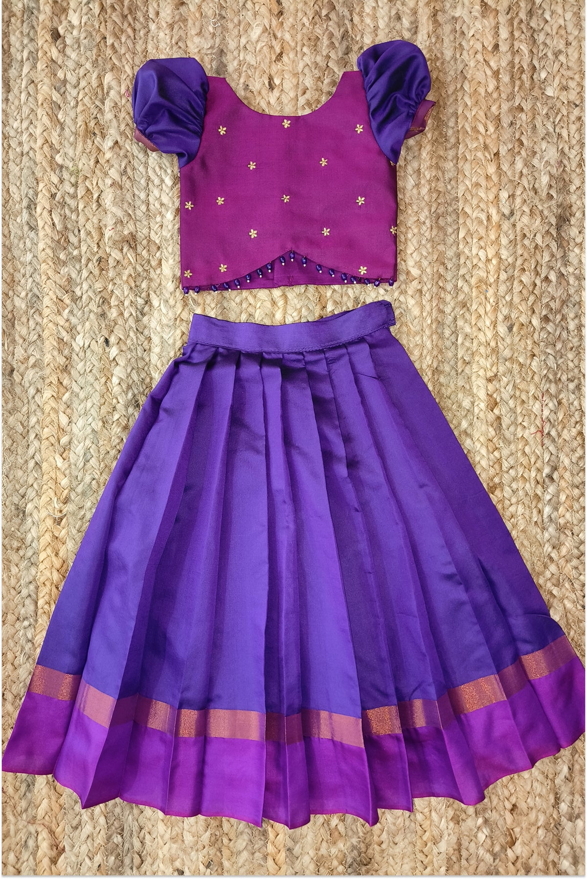 Purple pleated lehanga with golden zari border and magenta band - back view