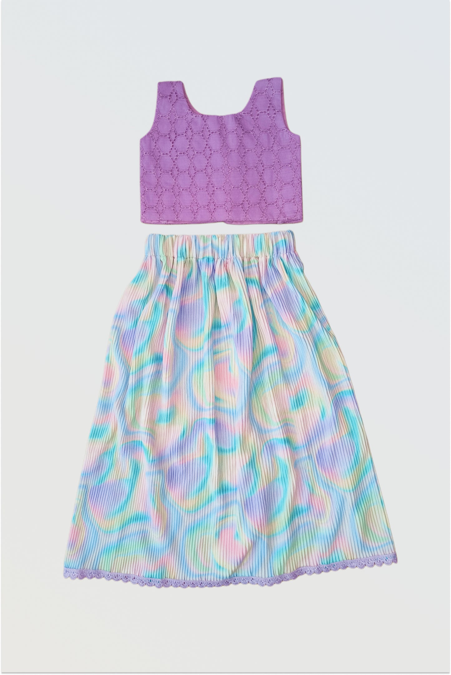 Accordion pleated colourful holi lehanga set flat lay showing hakoba textured choli and colorful pleated skirt