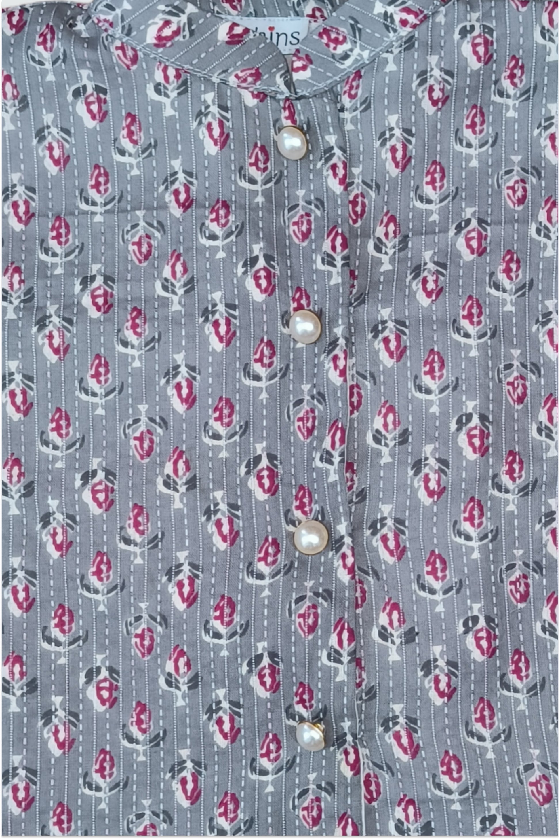 Close up of grey block printed fabric with traditional kantha running stitch embroidery