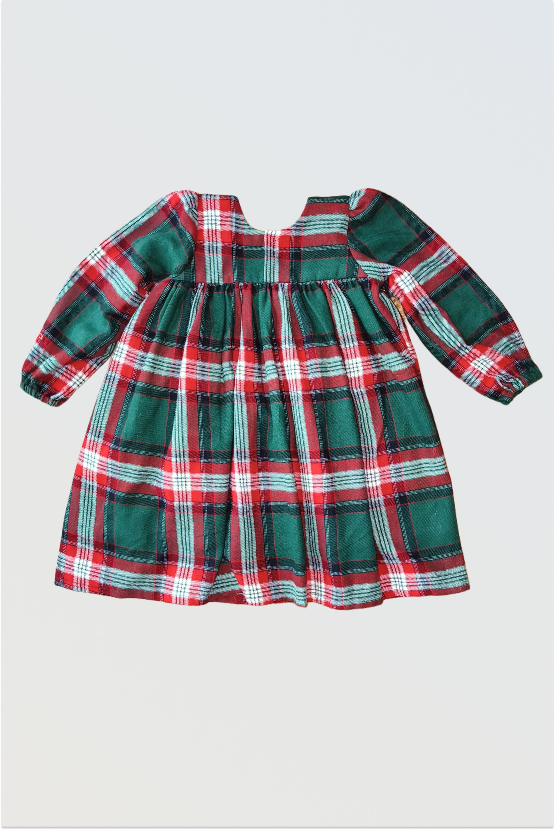 Back view of red green checkered winter dress showing single hook closure and gathered pleats