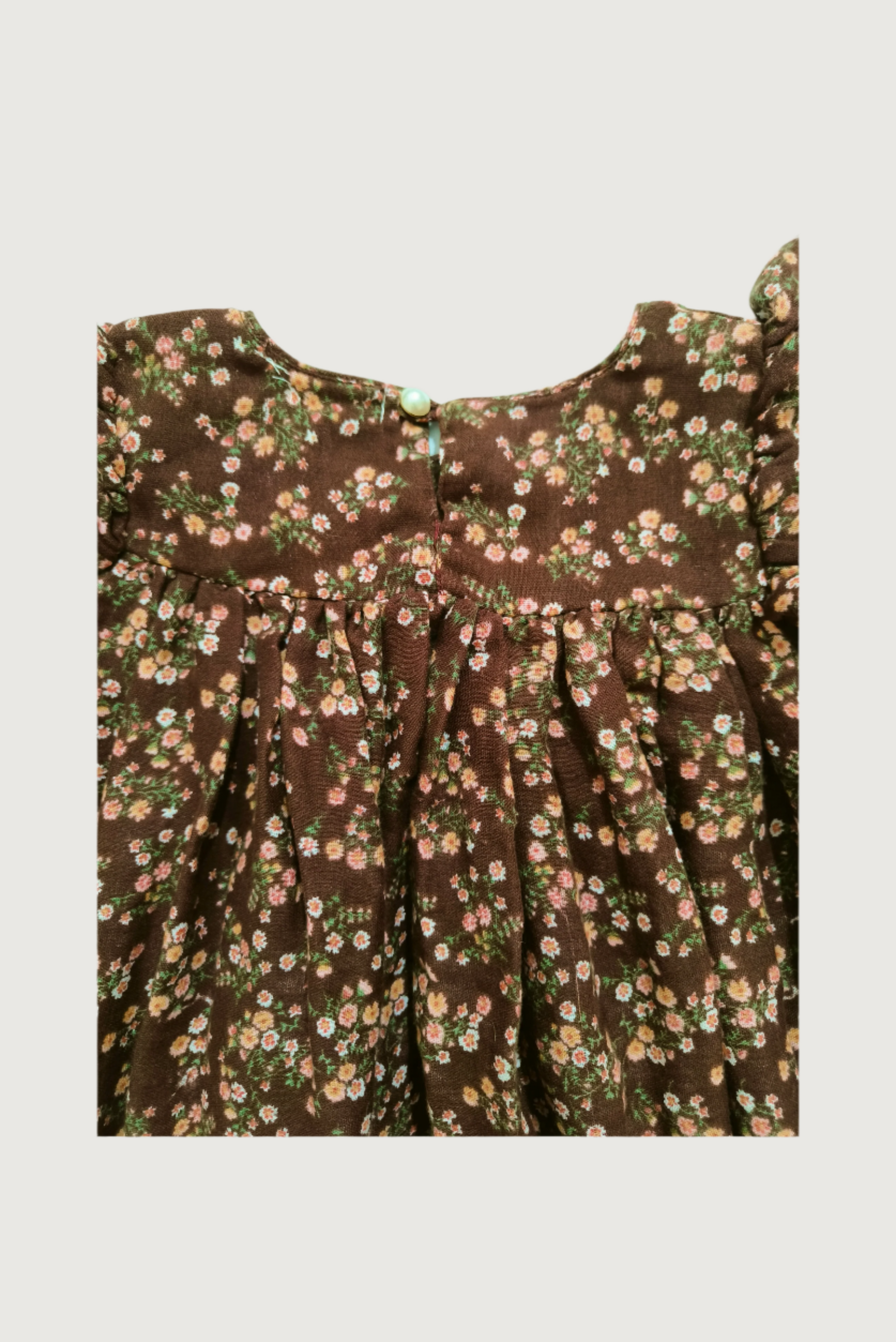 Close up of handcrafted crochet lace trim on brown floral dress empire waist