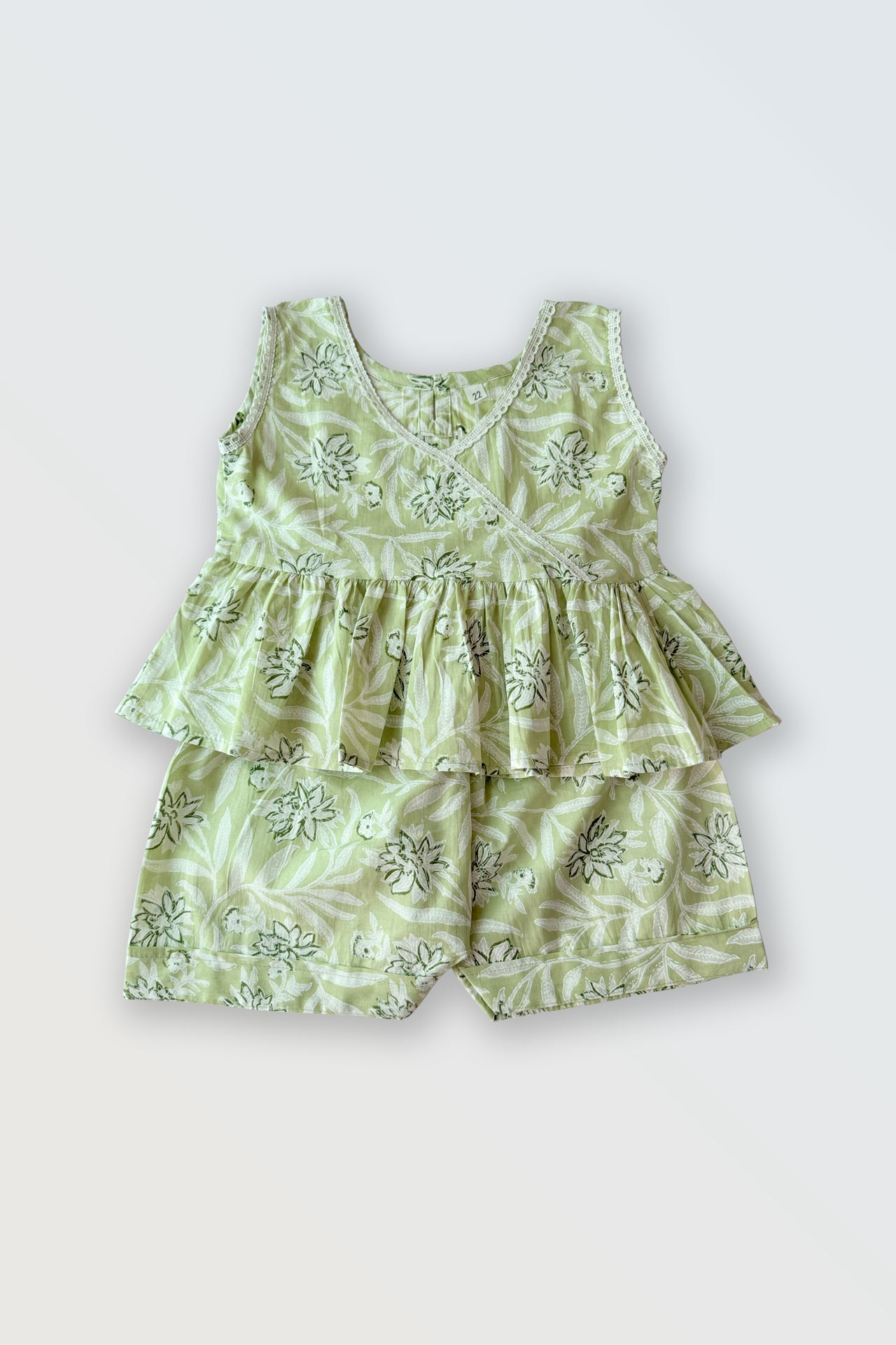 Girls summer co-ord set flat lay showing green ruffled top with lace and matching shorts