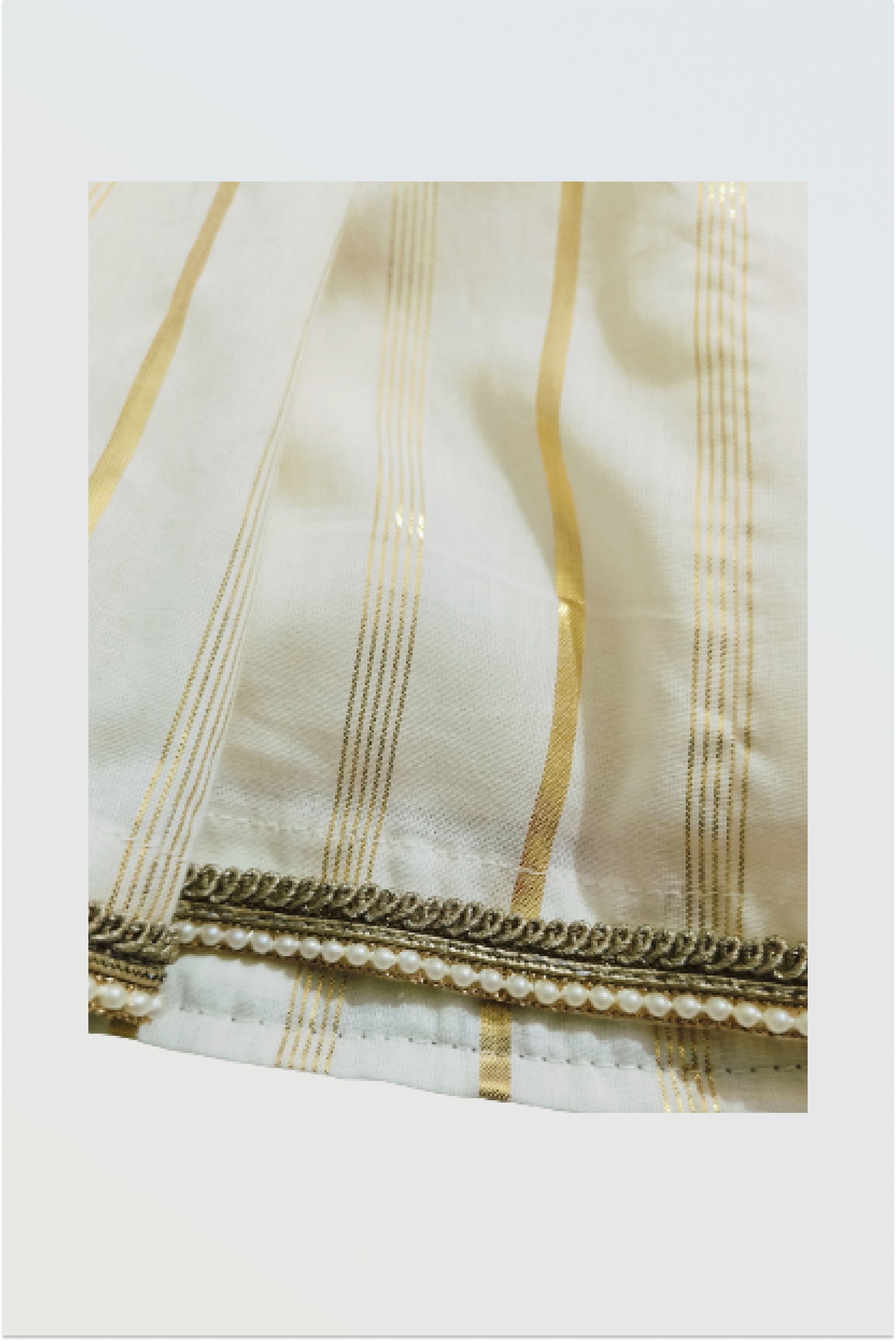 Close up of traditional kasavu cotton fabric with golden lurex border detail