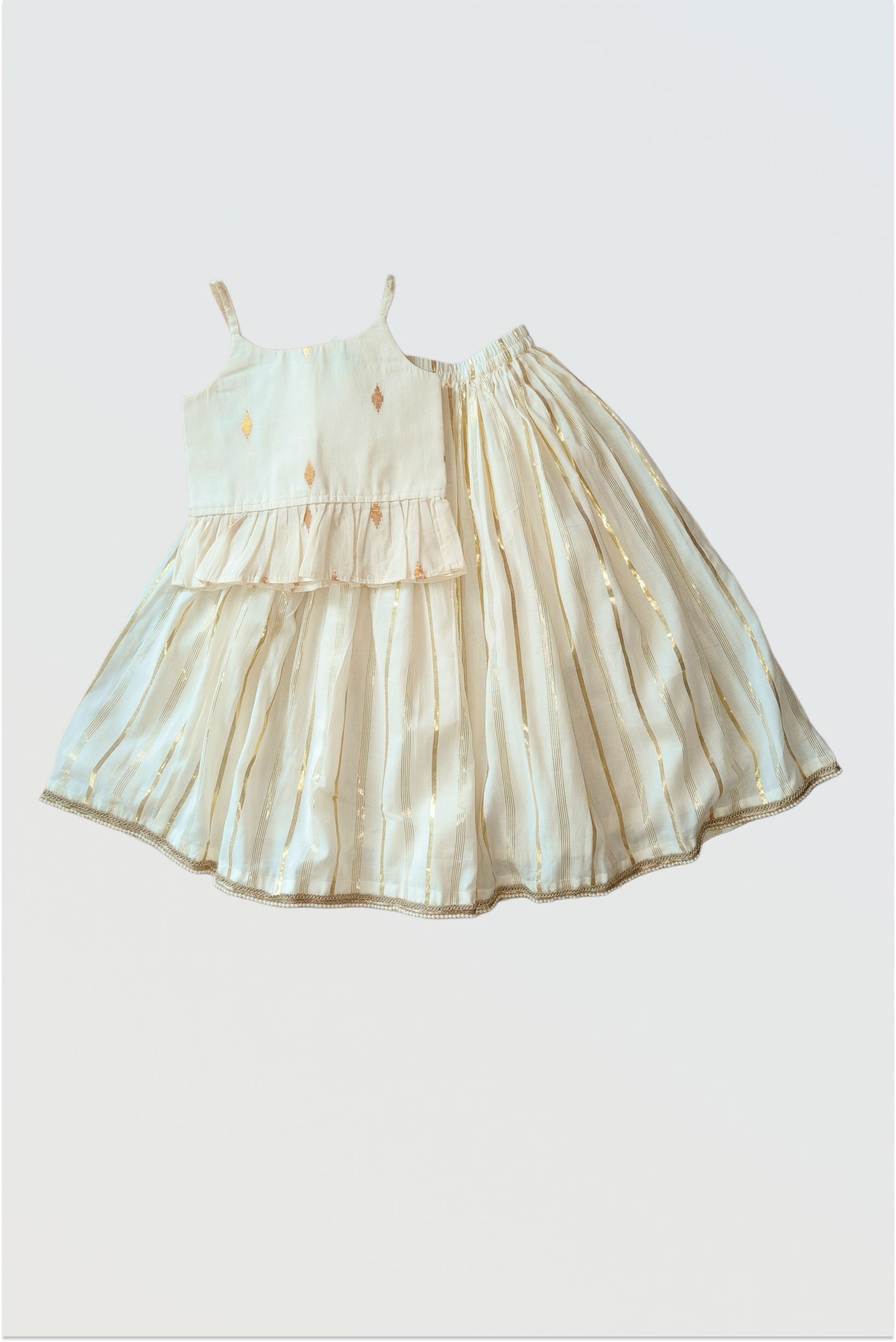 Kasavu lehanga choli set flat lay showing strappy blouse and flared skirt with golden border