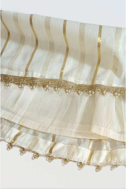 Close up of kasavu lehanga skirt showing golden lurex stripes and pearl lace trim detail