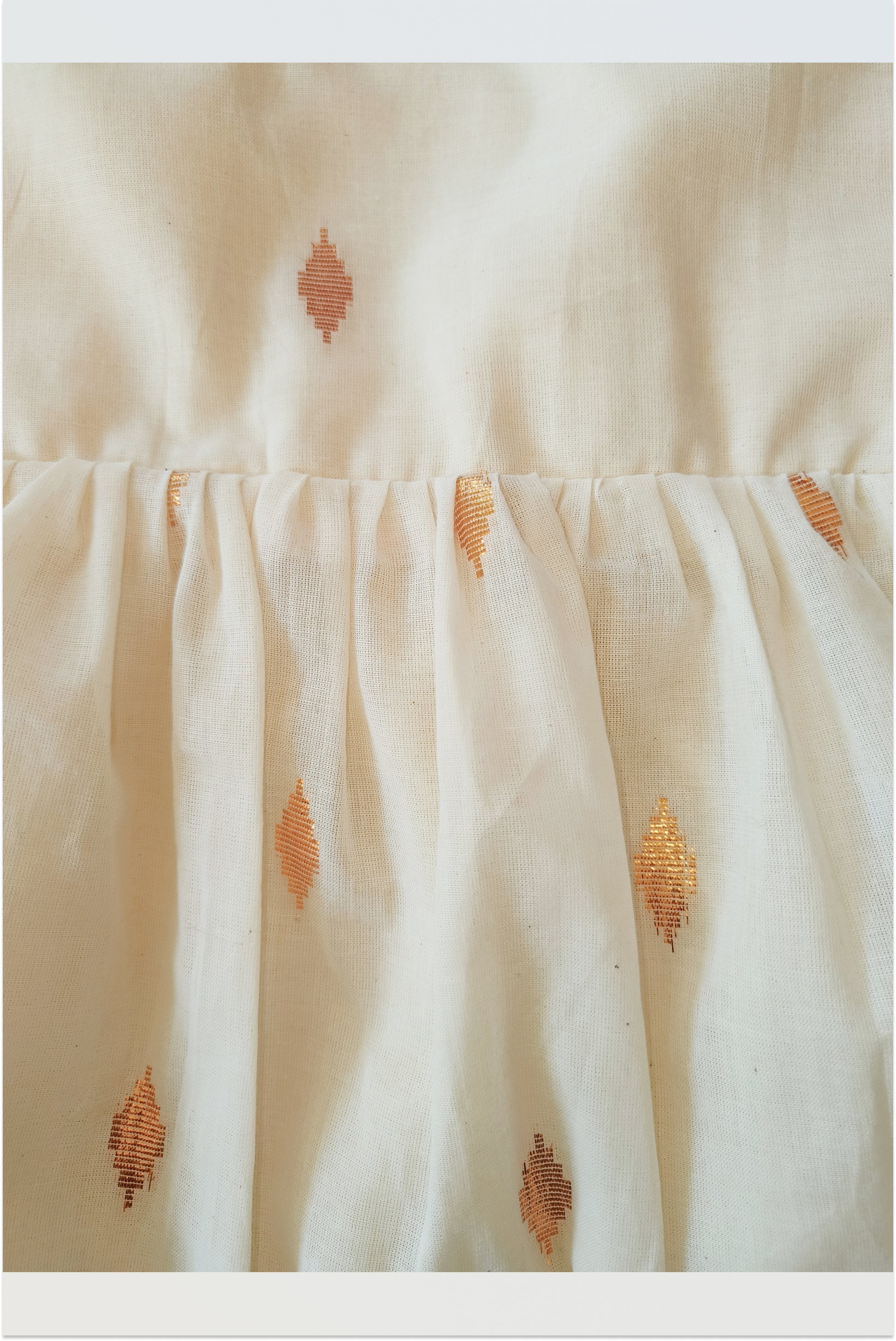 Close up of kasavu tie-up frock showing golden lurex stripes and pure cotton fabric detail