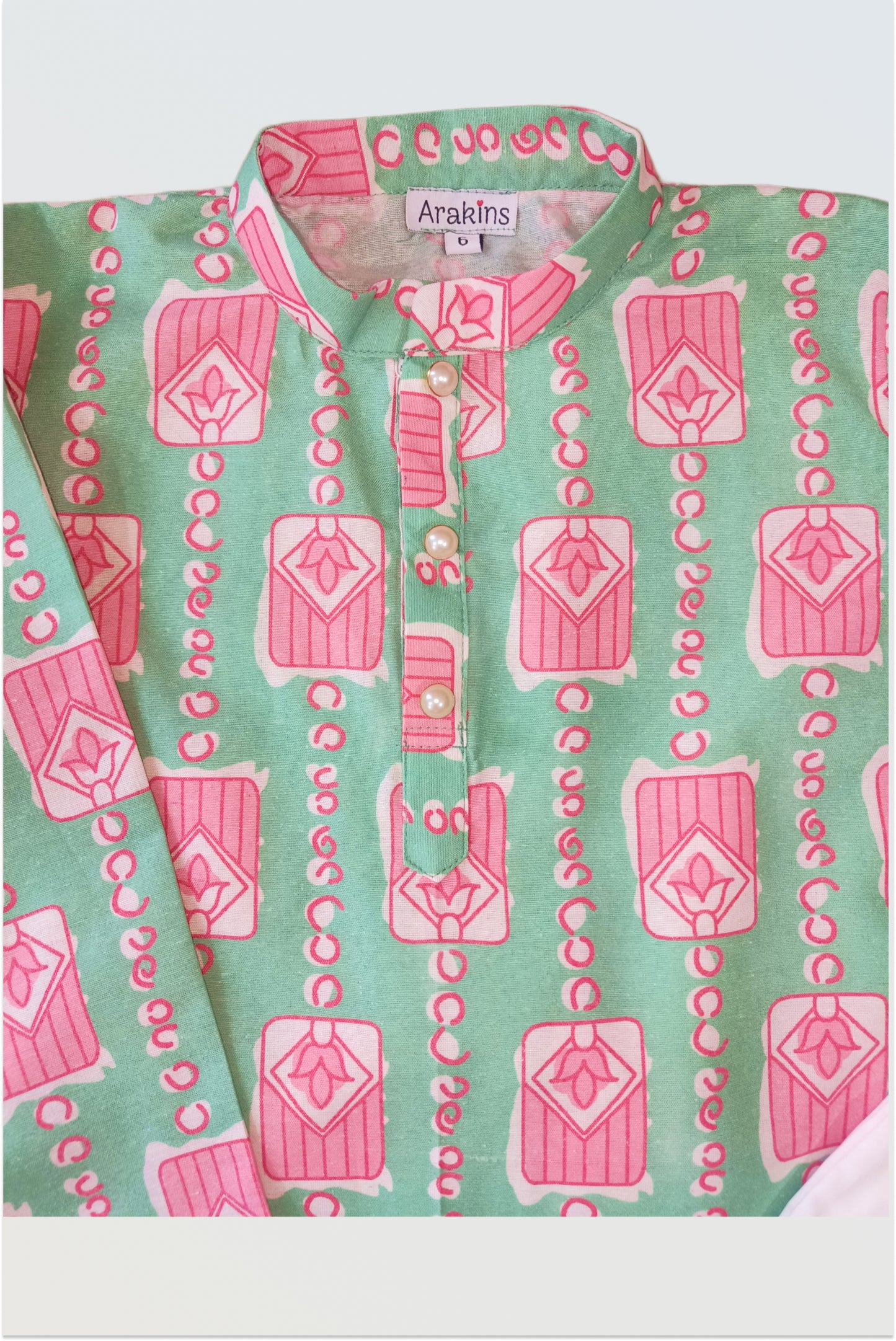 Close up of mint green kurta showing pink floral block print detail and linen texture