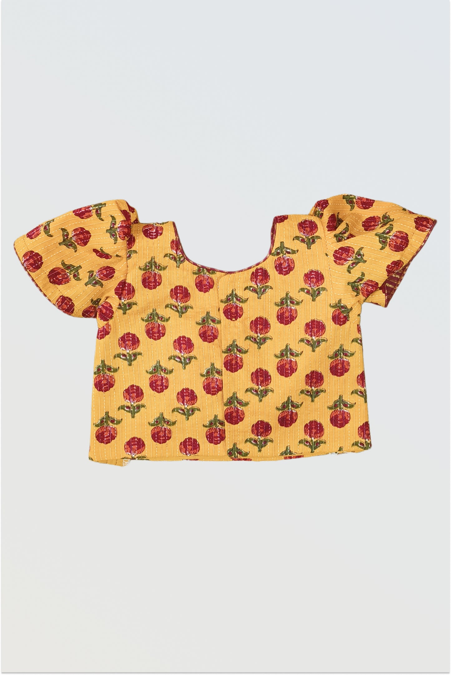 Back view of mustard block print choli showing hook closure and puffed sleeves