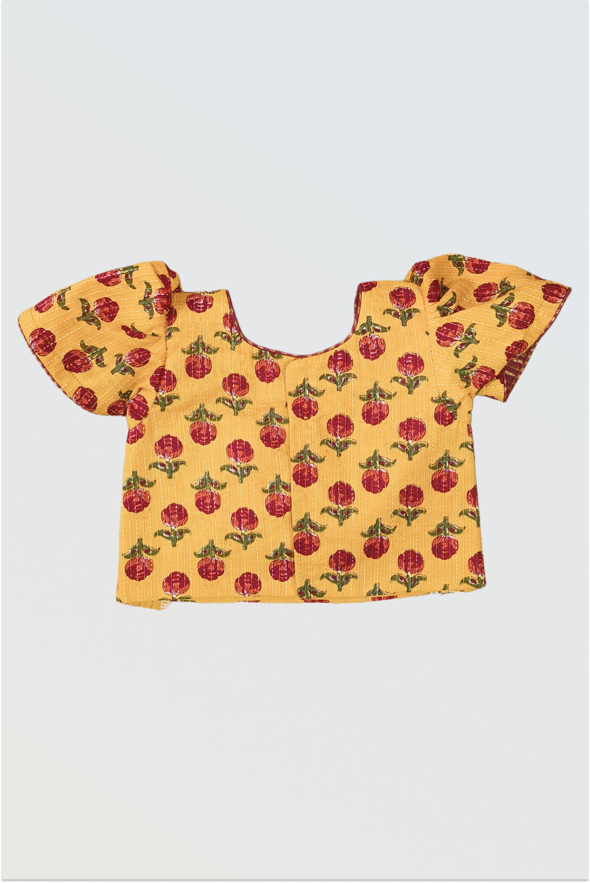 Back view of mustard block print choli showing hook closure and puffed sleeves