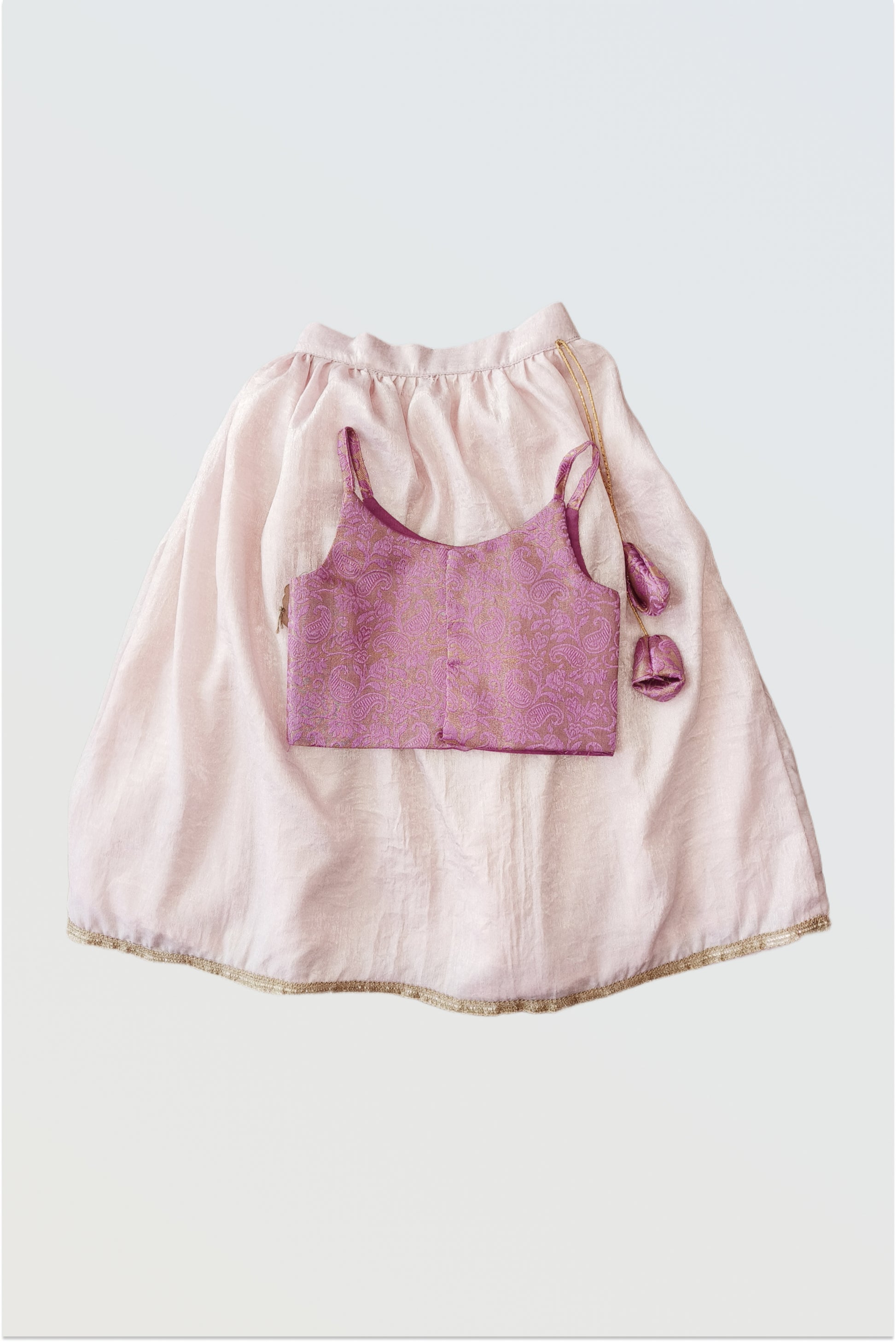 Back view of pink brocade lehanga set showing tassel tie-up details and full outfit