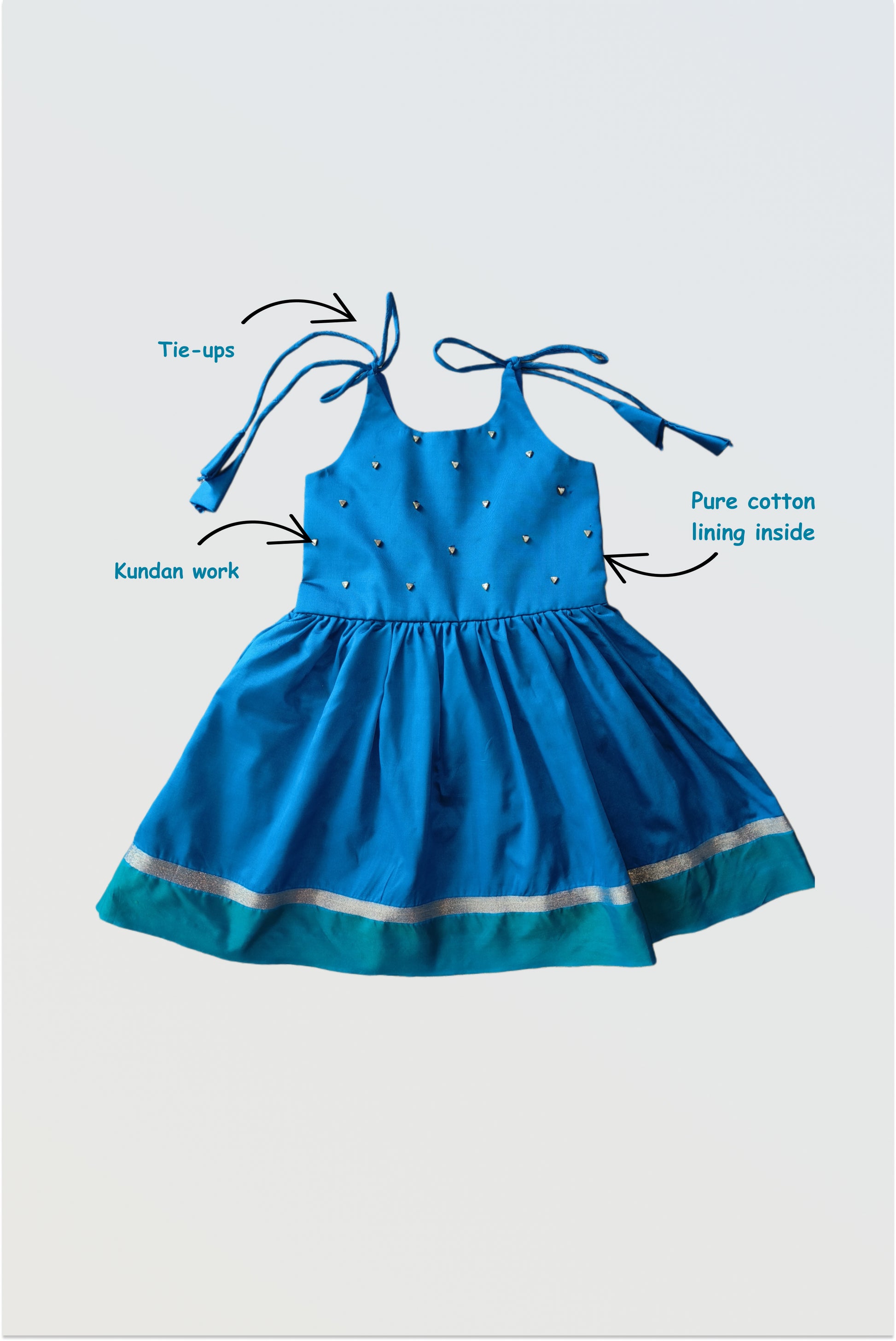 Traditional silk tie-up frock flat lay showing kundan stone embellishments on front