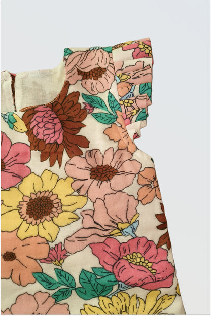 Close up of Summer Bloom dress showing flutter cap sleeves and oversized floral print detail