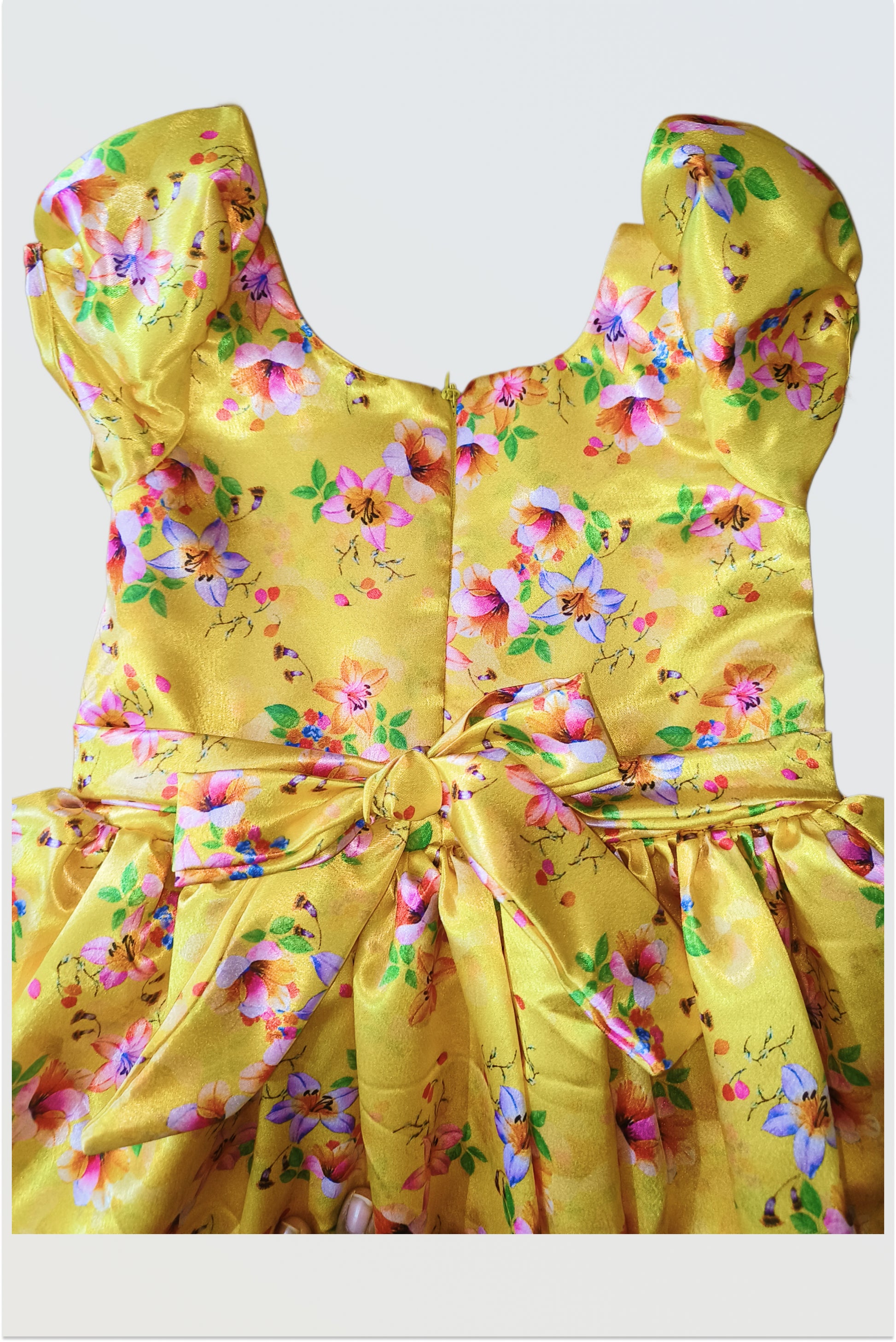 Close up of luxurious yellow satin fabric with elegant floral print pattern detail