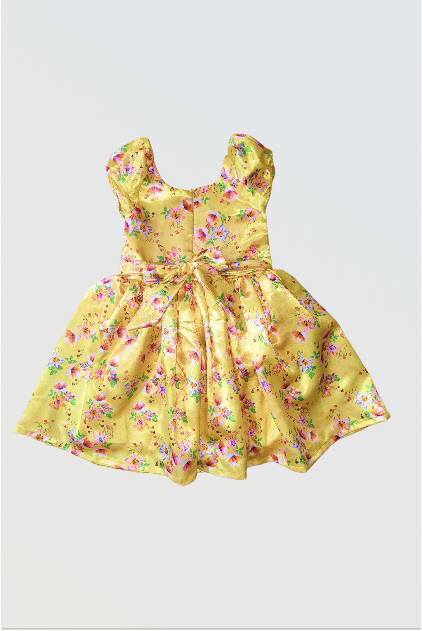 Back view of yellow satin dress showing zip closure and decorative tie-up belt detail